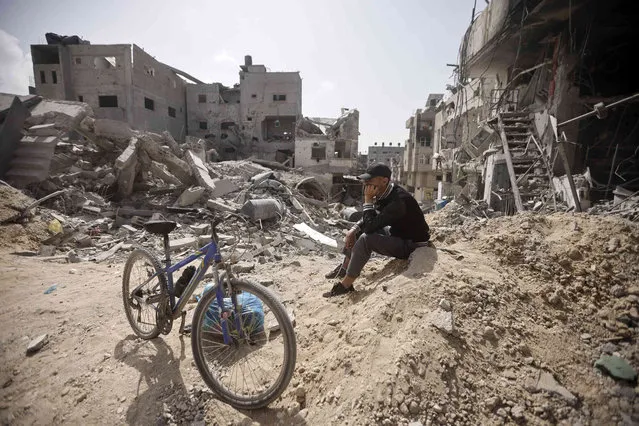 A Palestinian sits among destruction after Israeli forces left Khan Younis, Gaza Strip, Wednesday, March 6, 2024. (Photo by Mohammed Dahman/AP Photo)