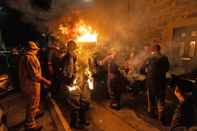 People carry a burning barrel of tar on Wednesday, January 11, 2023 during the Burning of the Clavie, a fire festival unique to Burghead in Moray, which greets the New Year twice, on the 11th January and the more traditional 1st January. The tradition, dates back to the 1750's, when the Julian calendar was reformed in Britain and the new Gregorian calendar was introduced. People rioted, demanding back their 11 days, although not in Burghead, where they decided to celebrate twice. (Photo by Paul Campbell/PA Images via Getty Images)