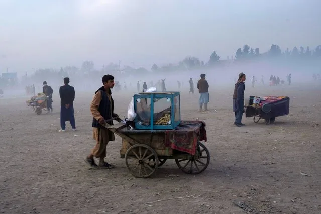 Street vendors push their carts in Chaman-e-Hozori park, Kabul, Afghanistan, Friday, December 3 , 2021. (Photo by Petros Giannakouris/AP Photo)