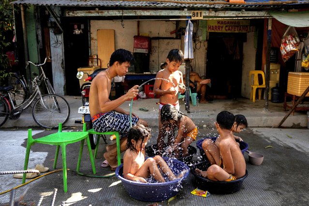 Children sit in buckets and basins during a hot day in Manila, Philippines, on April 29, 2024. (Photo by Eloisa Lopez/Reuters)