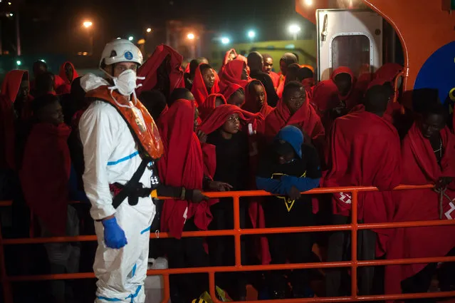 A group of migrants stand on a rescue boat after their arrival at the Port of Malaga on July 18, 2019. Spain's Maritime Rescue service rescued a total of 115 migrants aboard two dinghies crossing the Alboran Sea and brought them to Malaga harbor, where they were assisted by the Spanish Red Cross. (Photo by Jesus Merida Luque/SOPA Images/Shutterstock)