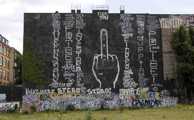 A giant obscene graffiti is pictured on a building next to a formerly squatted property on Cuvry Strasse in Berlin's Kreuzberg district, Germany, June 25, 2015. Unknown people painted an obscene gesture and slogans to protest against the planned property development with new appartments in the area. (Photo by Fabrizio Bensch/Reuters)