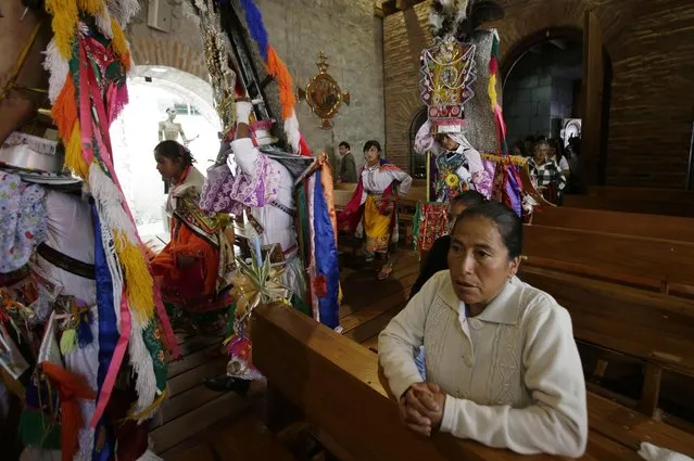 In this June 4, 2015 photo, a group of dancers enter the church, marking the start of the Corpus Christi festival, in Pujili, Ecuador. The priest authorizes the entry of the dancers who then perform dancers in honor of the Christian God. This mix of indigenous and Catholic traditions show the syncretic character of the Ecuadorian Andean cultural heritage. (Photo by Dolores Ochoa/AP Photo)