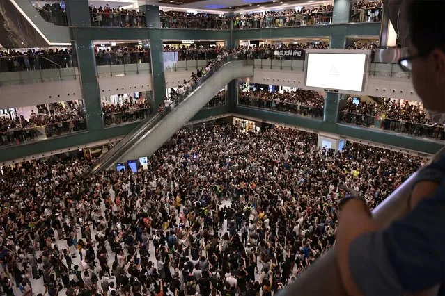 People gather at a shopping mall in the Shatin area of Hong Kong on September 11, 2019, to sing a recently penned protest song titled “Glory to Hong Kong” which has been gaining popularity in the city. (Photo by Nicolas Asfouri/AFP Photo)