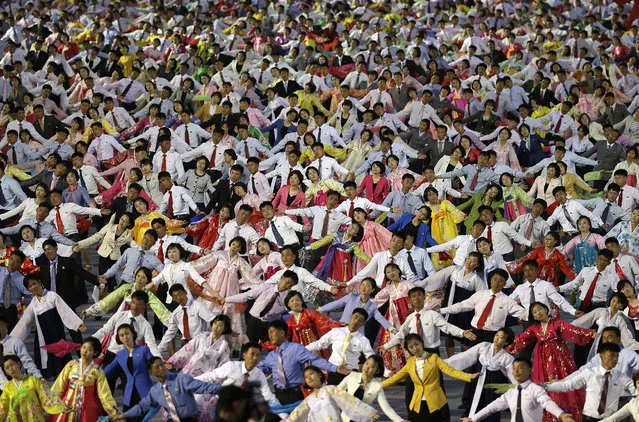 North Korean youths participate in a mass dance party on the Kim Il Sung Square on Tuesday, May 10, 2016, in Pyongyang, North Korea. Hundreds of thousands of North Koreans celebrated the country's newly completed ruling-party congress Tuesday with a massive civilian parade featuring floats bearing patriotic slogans and marchers with flags and pompoms, and celebrations followed on into the evening with a torchlight parade and mass dance party by youths. (Photo by Wong Maye-E/AP Photo)