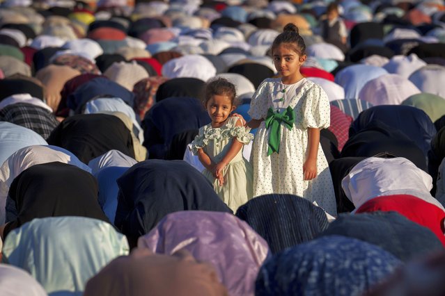 Little girls stand among men during Eid al-Adha prayers, held on the athletics track of the Dinamo stadium in Bucharest, Romania, Sunday, June 16, 2024. (Photo by Vadim Ghirda/AP Photo)