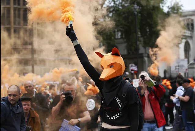 Protestors dressed as foxes demonstrate in front of the Houses of Parliament in London, Tuesday, July 14, 2015 urging policymakers to keep Britain humane by keeping the Hunting Act intact. The government has called off the scheduled vote for Wednesday on fox hunting. (Photo by Frank Augstein/AP Photo)