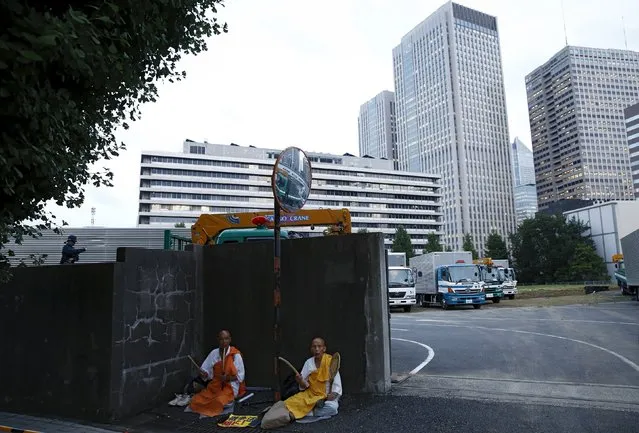 Buddhist protesters beat drums as they sit at the fringes of a demonstration against Japan's Prime Minister Shinzo Abe's security-related legislation outside the parliament building in Tokyo, July 17, 2015. (Photo by Thomas Peter/Reuters)