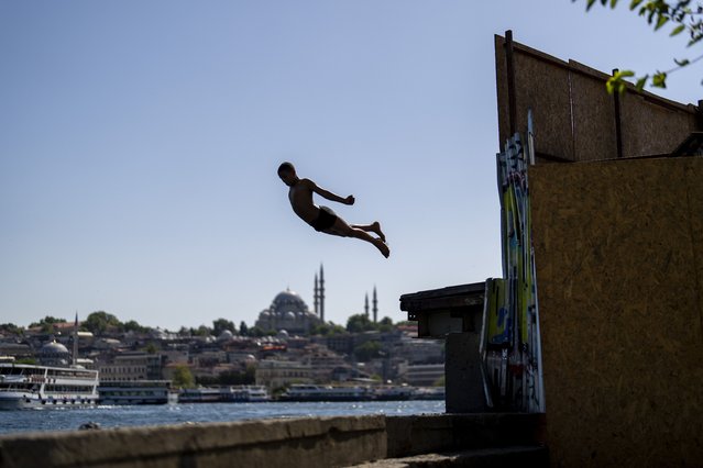 A youngster dives into the Bosphorus to cool off during a summer day in Istanbul, Turkey, Thursday, June 27, 2024. (Photo by Francisco Seco/AP Photo)