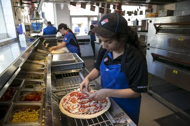 A worker prepares a vegan pizza at a Domino's Pizza restaurant in Tel Aviv, Israel July 16, 2015. A growing trend has transformed Israel's financial center into a haven for meatless cuisine. Some 400 food establishments are certified “vegan friendly”, including Domino's Pizza, the first in the global chain to sell vegan pizza topped with non-dairy cheese. (Photo by Baz Ratner/Reuters)