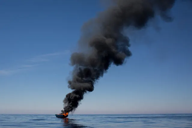 A small wooden boat used by refugees and migrants is seen burning after being set alight after all people were rescued by rescue crews from the Migrant Offshore Aid Station (MOAS) Phoenix vesselon May 18, 2017 in the Lampedusa, Italy. Numbers of refugees and migrants attempting the dangerous central Mediterranean crossing from Libya to Italy has risen since the same time last year with more than 43,000 people recorded so far in 2017. MOAS is a Malta based NGO dedicated to providing professional search-and-rescue assistance to refugees and migrants in distress at sea. Since the start of the year MOAS have rescued and assisted 3214 people and are currently patrolling and running rescue operations in international waters off the coast of Libya. (Photo by Chris McGrath/Getty Images)