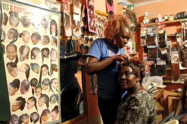 Elizabeth Aluoch has her hair done at a salon in the village of Kogelo, west of Kenya's capital Nairobi, July 15, 2015. (Photo by Thomas Mukoya/Reuters)