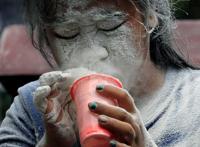 A girl's face is covered by a white powder after blowing on it, while participating in a game during a religious festival honouring patron saint Santa Rita de Cascia in Paranaque city, Metro Manila, Philippines May 21, 2017. (Photo by Romeo Ranoco/Reuters)