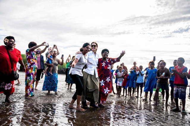 Crown Princess Mary of Denmark (C) dances with locals after planting mangroves in Nadi, Fiji, on April 27, 2023. Mangrove forests have several advantages in relation to climate change - they protect exposed coastal areas from flooding, and at the same time, mangroves can store far more CO2 than many other types of tropical forest. The Crown Princess and the Minister for Development Cooperation and Global Climate Policy Dan Jorgensen are visiting Vanuatu and Fiji from April 23 to 27, 2023. The visit focuses on the challenges that the local communities of the Pacific islands face in connection with climate change. (Photo by Ida Marie Odgaard/Ritzau Scanpix via AFP Photo)