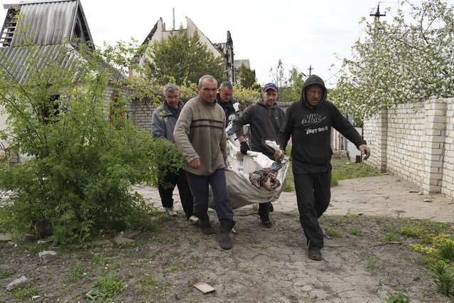 Volunteers exhume the bodies of civilians killed by Russian shelling in the village of Stepaky, close to Kharkiv, Ukraine, Wednesday, May 11, 2022. (Photo by Andrii Marienko/AP Photo)