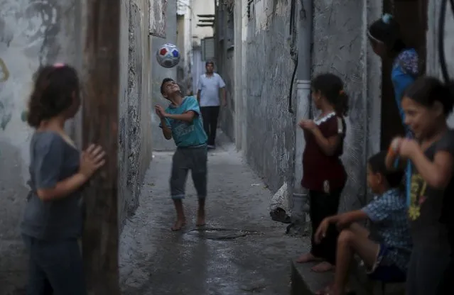 A Palestinian boy plays football outside his family house at Shatti (beach) refugee camp in Gaza City July 28, 2015. (Photo by Mohammed Salem/Reuters)