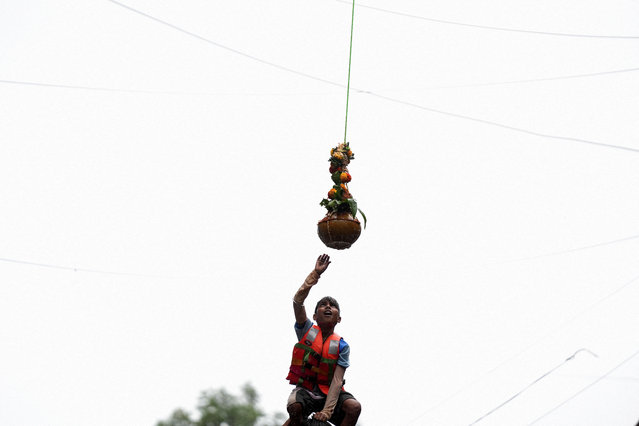 A devotee tries to break a clay pot containing curd during the celebrations to mark the Hindu festival of Janmashtami in Mumbai, India on August 27, 2024. (Photo by Hemanshi Kamani/Reuters)