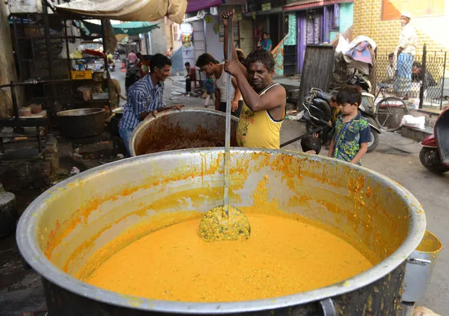 An Indian vendor prepares haleem to be sold to Muslim shoppers as they prepare to break their Ramadan fast in Ahmedabad on June 14, 2016. Across the Muslim world, the faithful fast from dawn to dusk and abstain from eating, drinking, smoking and having s*x during that time as they strive to be more pious and charitable. (Photo by Sam Panthaky/AFP Photo)