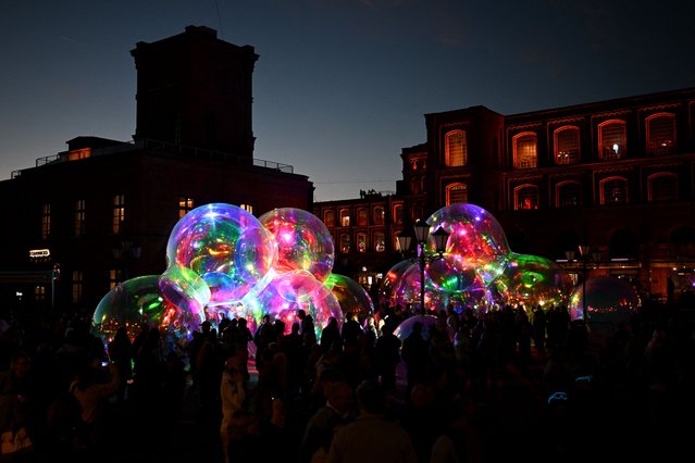 People enjoy the light installation “Back to childhood” created by DNA Group marketing agency during the annual festival of light in Lodz on September 28, 2024. (Photo by Sergei Gapon/AFP Photo)