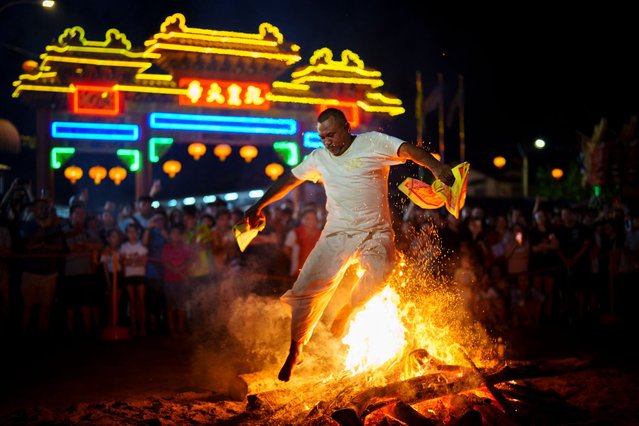 A worshipper jump over burning wood and coals barefoot during the Nine Emperor Gods festival at a temple in Kuala Lumpur, Malaysia, Monday, October 7, 2024. (Photo by Vincent Thian/AP Photo)