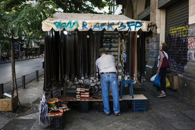The owner of a kiosk arranges his goods in central Athens, Greece on June 25, 2016. (Photo by Angelos Tzortzinis/AFP Photo)