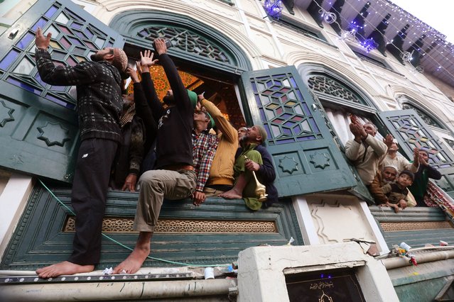 Muslim devotees pray as a priest displays a relic of Sheikh Syed Abdul Qadir Jeelani at his shrine in Srinagar, India, 15 October 2024. Thousands of devotees thronged to the shrine housing the relic as part of an 11-day festival to mark the death anniversary of the 11th and 12th-century Sufi mystic saint Sheikh Syed Abdul Qadir Jilani. (Photo by Farooq Khan/EPA)