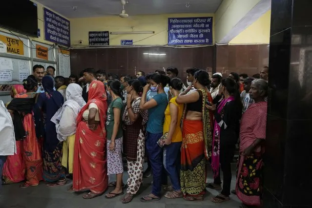 People crowd the registration counter at Tej Bahadur Sapru Hospital in Prayagraj, Uttar Pradesh state, India, Thursday, June 23, 2022. The hospital is experiencing heavy rush this summer with several patients turning up with heat related ailments. (Photo by Rajesh Kumar Singh/AP Photo)