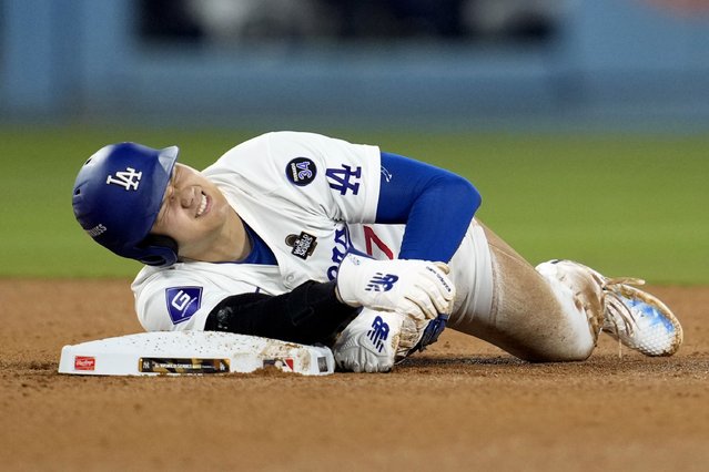 Los Angeles Dodgers' Shohei Ohtani holds his arm after being injured while trying to steal second base during the seventh inning in Game 2 of the baseball World Series against the New York Yankees, Saturday, October 26, 2024, in Los Angeles. (Photo by Godofredo A. Vásquez/AP Photo)