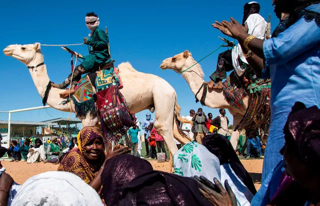 Nomads parade on camels in the Agadez stadium under the songs of Tuareg women, on the occasion of the Grand Marathon du Ténéré on 29 December 2019. In a Saharan setting of acacias and camels, runners participated on December 29, 2019, in the first marathon in the history of Niger, near the city of Agadez under the close surveillance of dozens of soldiers deployed to avoid any attack by jihadists. (Photo by Nora Schweitzer/AFP Photo)