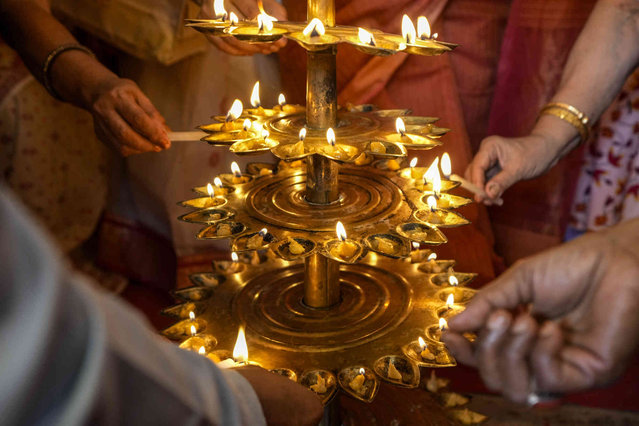 Devotees light oil lamps on the auspicious juncture of the day during the worship of Hindu goddess Durga on third day, in Kolkata, India, Friday, October 11, 2024. (Photo by Bikas Das/AP Photo)