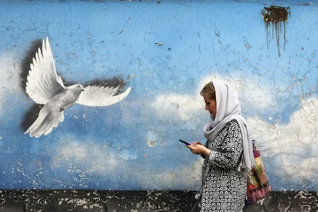 An Iranian woman walks past a wall painting of peace bird in a street in downtown of Tehran, Iran, 01 August 2022. According to Iranian foreign ministry there will likely be a new round of nuclear talks in Vienna soon following responds to top European Union diplomat Josep Borrell's proposal aimed at salvaging 2015 nuclear deal with world powers. Iran is facing economic crisis following the sanction by US and world powers over its nuclear programm. (Photo by Abedin Taherkenareh/EPA/EFE)