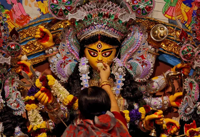 A devotee offers sweets to an idol of the Hindu goddess Durga while offering prayers on the last day of the Durga Puja festival in Kolkata, September 30, 2017. (Photo by Rupak De Chowdhuri/Reuters)