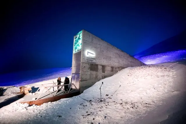 People stand in front of the entrance to the international gene bank Svalbard Global Seed Vault (SGSV), on February 25, 2020 outside Longyearbyen on Spitsbergen, Norway. The Arctic “doomsday vault” is set on February 25, 2020, to receive 60,000 samples of seeds from around the world as the biggest global crop reserve stocks up for a global catastrophe. (Photo by Lise Åserud/NTB Scanpix/AFP Photo)