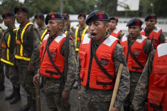 Guatemalan army soldiers sing  as they stand for review at their base, before the arrival of Hurricane Earl in Puerto Barrios, Guatemala, Tuesday, August 3, 2016. Hurricane Earl bore down on the coast of the Caribbean nation of Belize with the danger of high surf and winds, while also threatening neighboring Guatemala and southern Mexico with torrential rains. (Photo by Luis Soto/AP Photo)