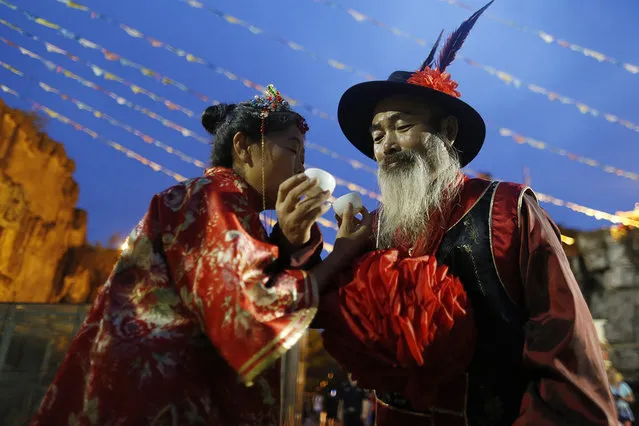 An old couple at the age of around 60 hold a Chinese traditional wedding in Hangzhou City, capital of east China's Zhejiang Province on August 4, 2016, to embrace the upcoming Chinese Valentine's Day. The couple Zhang Chunhua and Han Xuelu got married simply without a wedding thirty-five years ago. With the deep love towards handicrafts, they spent more than 16 hours in making handicrafts of ships every day. They had won the first prize of China Folk Art Expo for their outstanding handicraft skills. They have been living a simple and unadorned life in a small house of 50 square meters with a low daily income of about RMB 100 yuan. (Photo by Zhu Weiguo/ZUMA Press/Splash News)