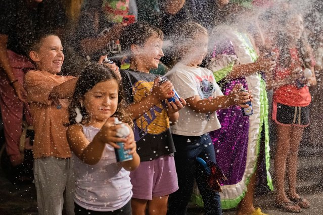 Children spray foam at performers during a Carnival parade in Montevideo, Uruguay, Wednesday, February 19, 2025. (Photo by Matilde Campodonico/AP Photo)