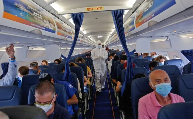 A stewardess of Israir Airlines wearing full PPE (personal protective equipment) prepares for take off from the Ben Gurion International Airport near the central Israeli city of Tel Aviv to southern Israeli Red Sea resort city of Eilat amid the COVID-19 pandemic, on June 16, 2020. (Photo by Gil Cohen-Magen/AFP Photo)