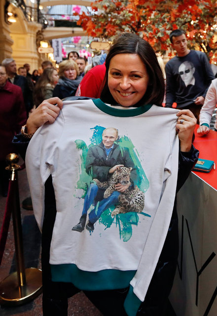 A Russian customer shows a sweatshirt with a printed image of Russian President Vladimir Putin in the GUM department store in Moscow, Russia, 06 October 2014. (Photo by Yuri Kochetkov/EPA)