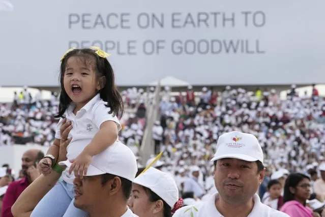 A girl sings on the shoulder of her father who arrived to attend a Holy Mass that will be held by Pope Francis at Bahrain National Stadium in Manama, Bahrain, Saturday, November 5, 2022. (Photo by Hussein Malla/AP Photo)