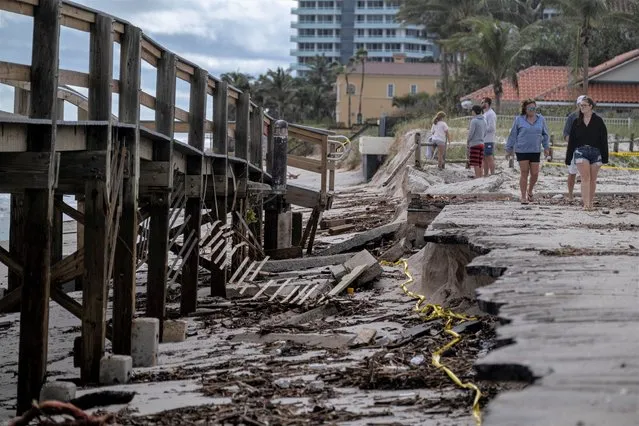 People walk by a closed down damaged boardwalk following the passage of Hurricane Nicole in Vero Beach, Florida, U.S. November 10, 2022. (Photo by Ricardo Arduengo/Reuters)