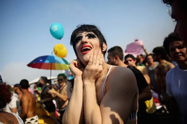 Revelers celebrate during an LGBT pride march on Copacabana Beach on October 12, 2014 in Rio de Janeiro, Brazil. The city will host the Rio 2016 Olympic Games in less than two years. (Photo by Mario Tama/Getty Images)