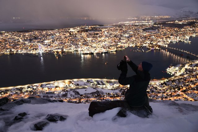 Admiring the scene over the city and river from a high viewpoint in Tromsø, Norway on January 14, 2025. (Photo by Jakub Porzycki/NurPhoto/Rex Features/Shutterstock)