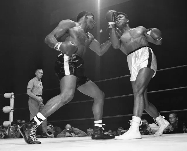 In this November 22, 1965, file photo, challenger Floyd Paterson, left, delivers a left hook to the chin of champion Muhammad Ali during the second round of their heavyweight title fight in Las Vegas. Among the questions Jonathan Eig wanted to answer in his upcoming biography of Ali was this: How many punches did Ali take during a career that ended with him devastated by Parkinson's? You'll have to wait until the book comes out to find out, though Ali himself once calculated the figure at 29,000. (Photo by AP Photo)