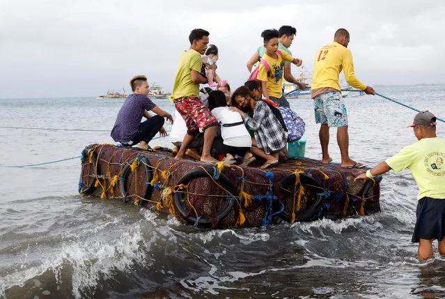 Stranded passengers ride on a makeshift raft after all ferry service were cancelled, a day after a Philippine vessel capsized because of bad weather in Infanta, Quezon in the Philippines, December 22, 2017. (Photo by Erik De Castro/Reuters)