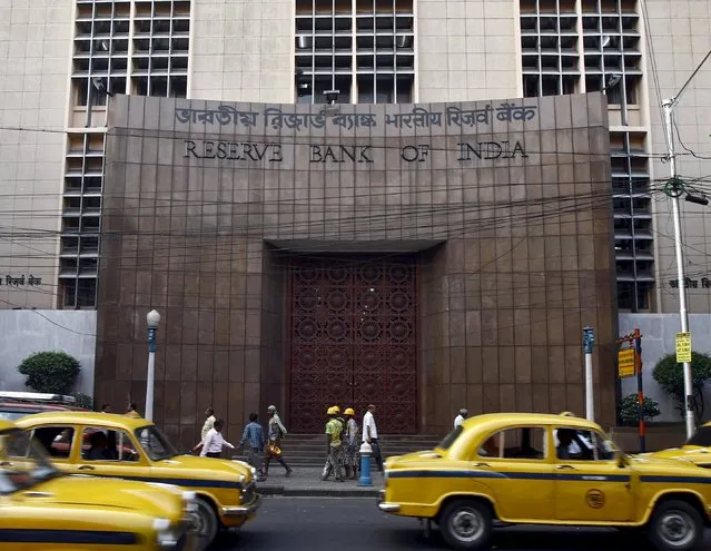 Commuters travel past a Reserve Bank of India (RBI) building in Kolkata in this November 11, 2014 file photo. Though the Reserve Bank of India is expected to cut interest rates next week by a quarter percent to a four-year low, officials say concerns over prices make it likely to resist political pressure for significant easing in the coming months. (Photo by Rupak De Chowdhuri/Reuters)