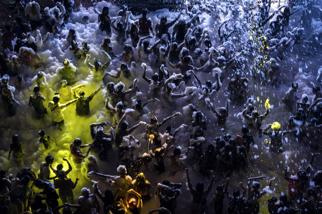 In this aerial view, Revelers dance while covered in foam spray during Carnival celebrations on February 12, 2024 in Esmeraldas, Ecuador. Violent crime has dropped nationwide, according to the government, in the month since Ecuador's President Daniel Noboa declared a state of “internal armed conflict” to fight surging gang violence. National Police and armed forces have arrested more than 7,000 people around the country. The government has labeled 22 gangs in Ecuador as terrorist organizations. In Esmeraldas Province on Ecuador's Pacific coast authorities allowed official Carnival events to resume this year due to the improved security situation after having cancelled main events in recent years due to widespread drug-related violence, extortion and death threats to residents. The instability forced many people to move to safer parts of Ecuador or emigrate abroad, many to the United States. (Photo by John Moore/Getty Images)
