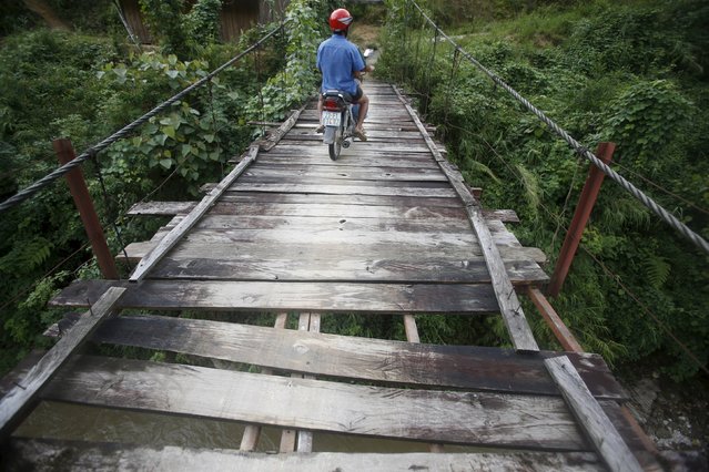 A man of the Dao ethnic tribe rides a motorcycle across a bridge in Hoang Su Phi, north of Hanoi, Vietnam September 18, 2015. (Photo by Reuters/Kham)