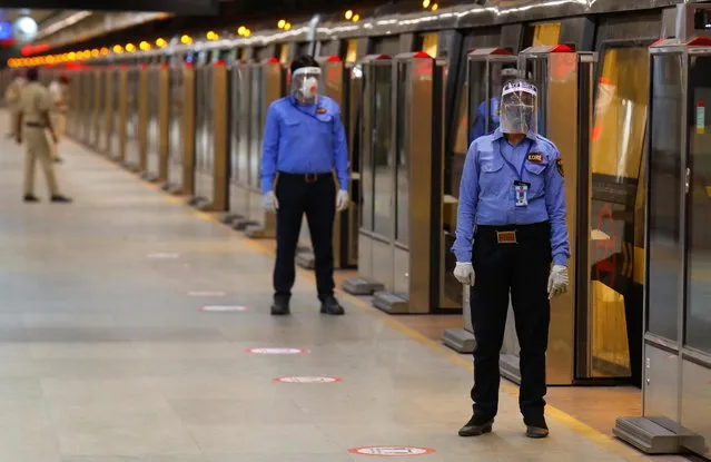 Security guards wearing face masks and shields stand on a Delhi metro train platform, on the first day of the restart of their operations, amidst the spread of coronavirus disease (COVID-19), in New Delhi, India, September 7, 2020. (Photo by Adnan Abidi/Reuters)