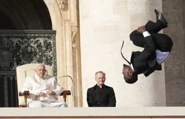 Pope Francis looks at an acrobat of the “Black Blues Brothers” performing during his weekly general audience in St. Peter's Square at The Vatican, Wednesday, Nov. 30, 2022. (Photo by Andrew Medichini/AP Photo)