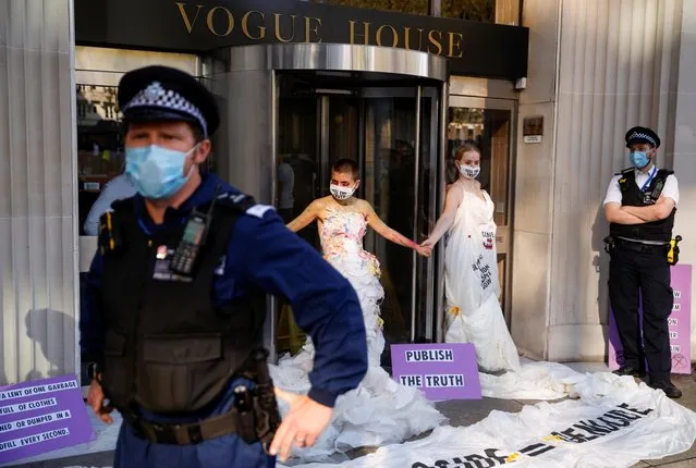 Police officers guard as activists of Extinction Rebellion Fashion Action are glued to the front door of Vogue House, during a protest outside Conde Nast in London Britain on September 22, 2020. (Photo by John Sibley/Reuters)